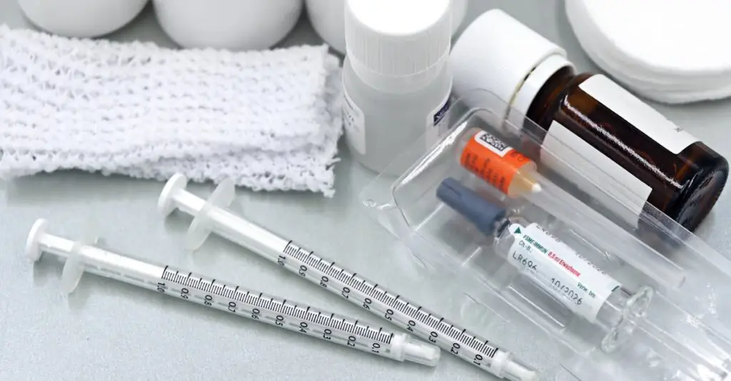 Flat lay of medical tools and vaccines, including syringes and bottles, on a white surface.